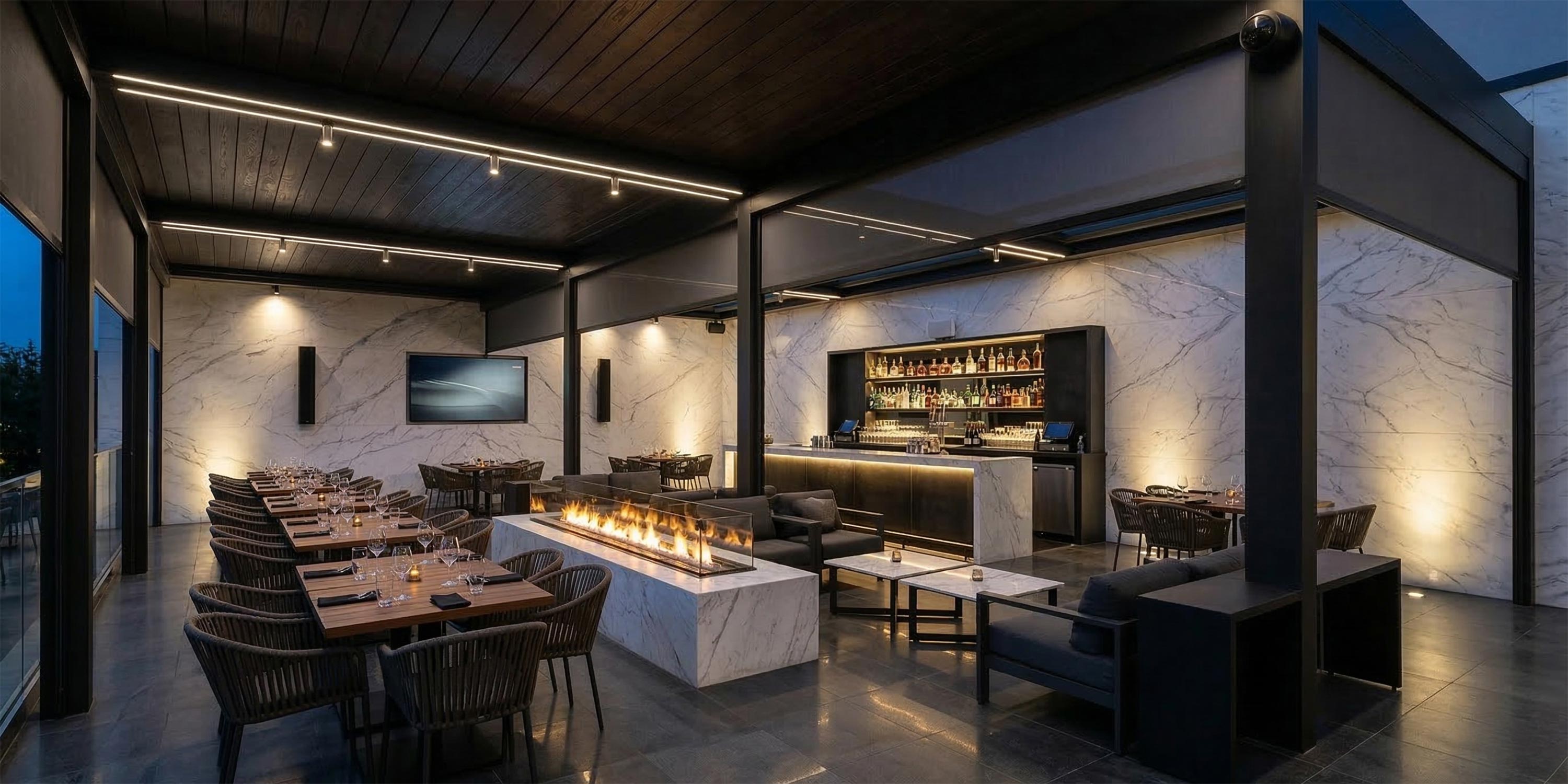 Rooftop patio with outdoor dining tables, bar, and linear fire pit