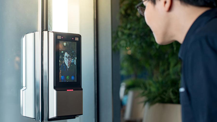 Man facing a digital access panel with a facial recognition screen