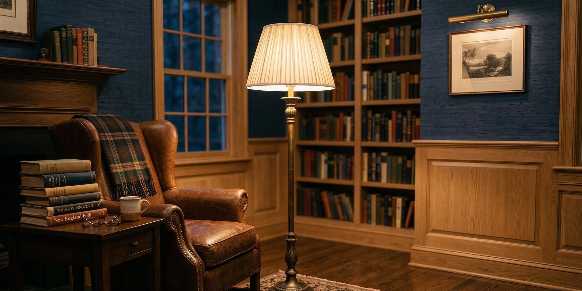 Classic floor lamp with pleated shade in a library with leather chair and bookshelves