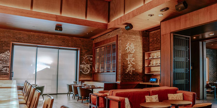 Modern restaurant interior with brick walls, wooden accents, and warm lighting