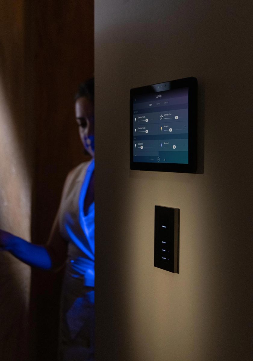 Smart home touchscreen panel and light switch mounted on a wall